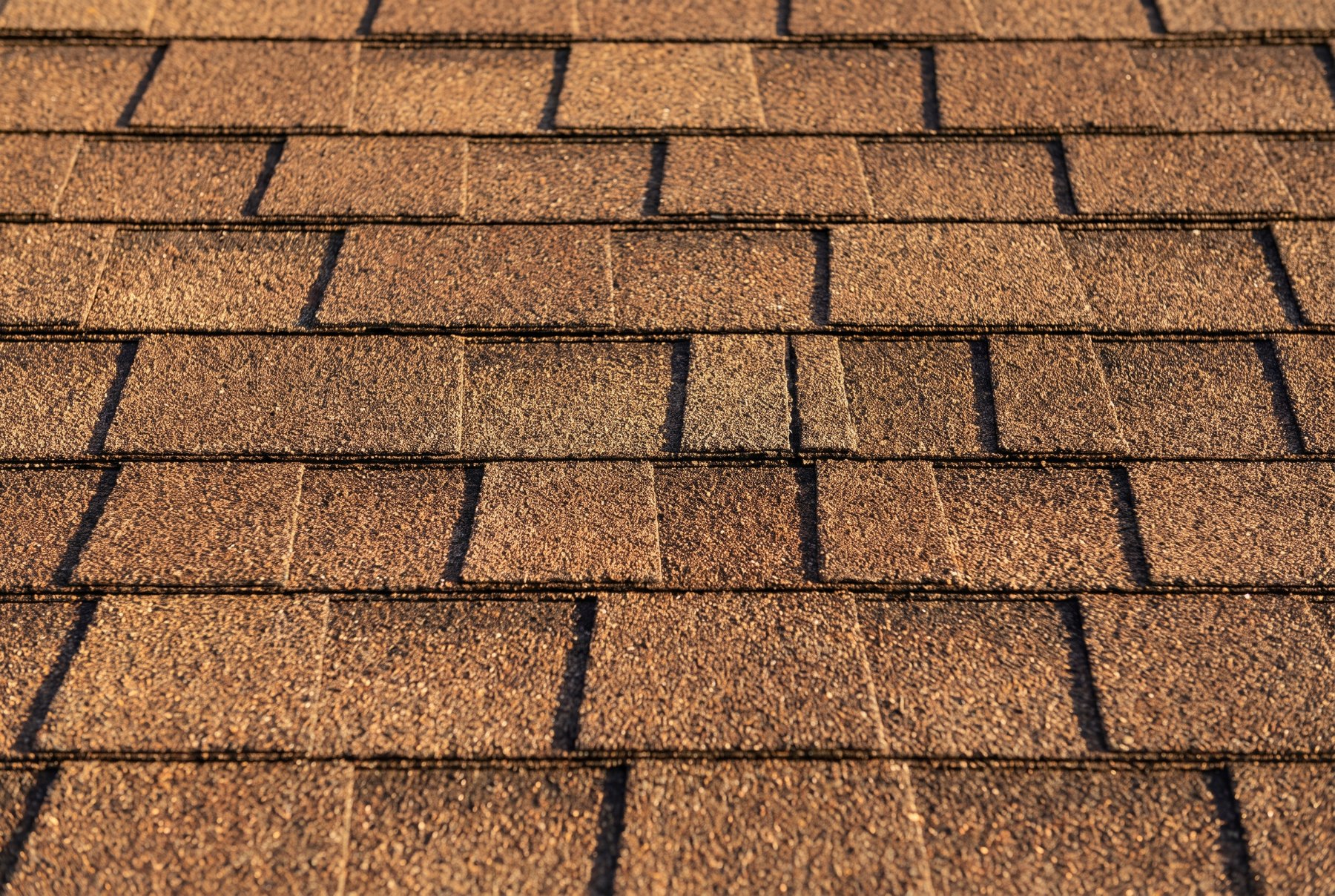 Gloved hands laying an architectural shingle in perfect alignment